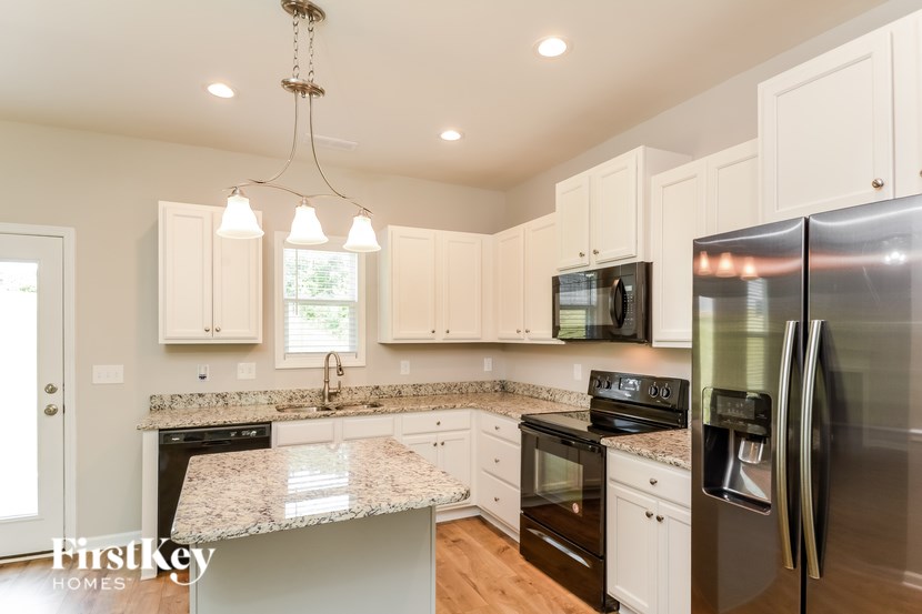 A kitchen with a granite countertop and stainless steel appliances.