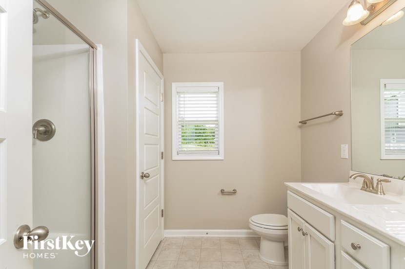A white bathroom with a toilet, sink, and mirror.