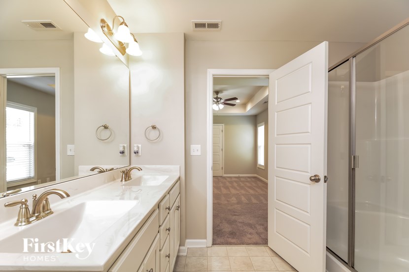 A bathroom with a white sink and a mirror.