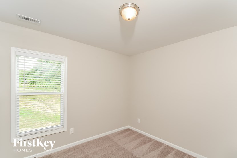 A room with a window and a ceiling light.