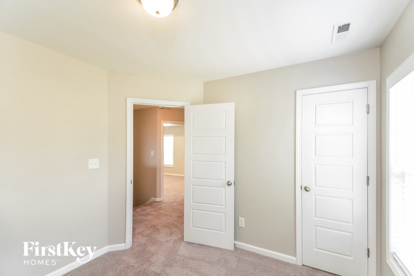 A room with two white doors and a carpeted floor.