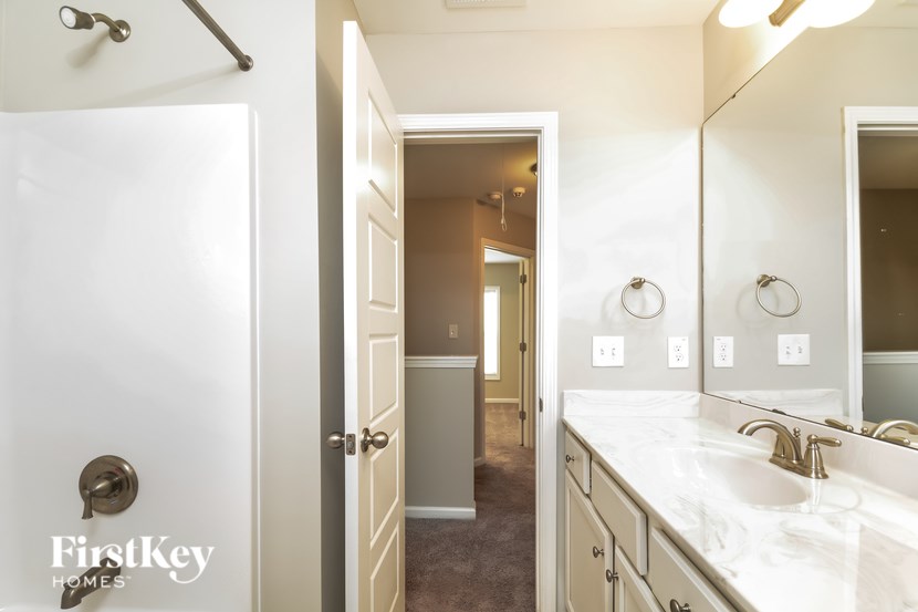 A bathroom with a white sink and a white door.