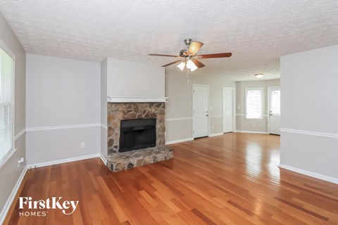 A living room with a fireplace and wood floors.