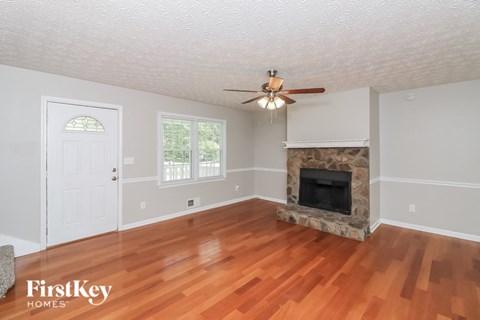 A room with a fireplace and a ceiling fan.