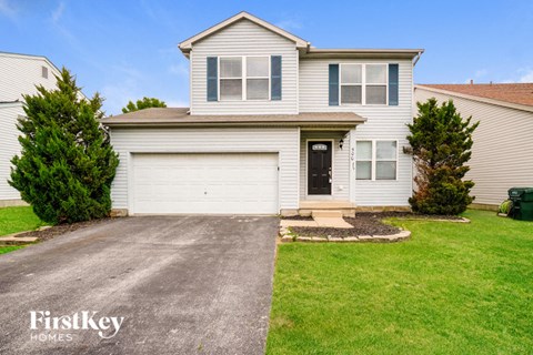 a white house with a white garage door and a green lawn