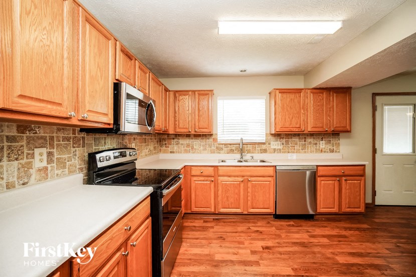 a kitchen with wooden cabinets and a stove and a sink