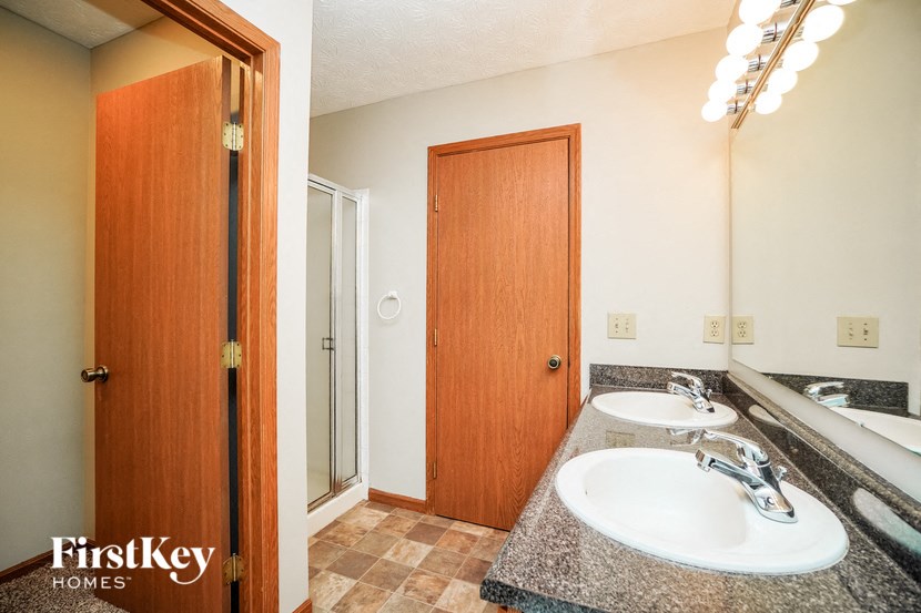 the master bathroom has two sinks and a shower