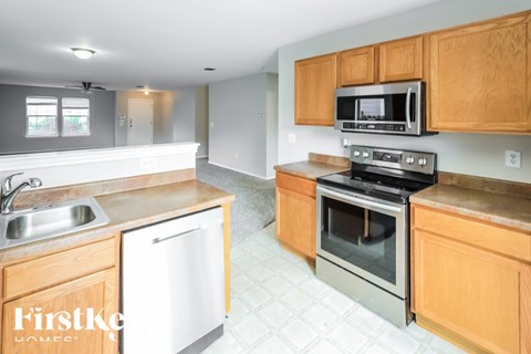 A kitchen with wooden cabinets and a stainless steel oven.