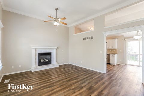 A spacious living room with a fireplace and wood flooring.