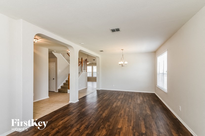 the living room and dining room with hardwood floors and white walls