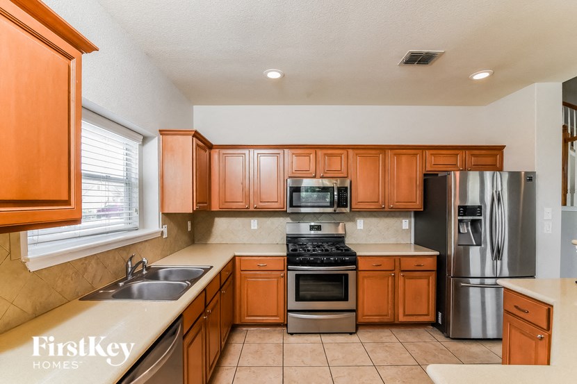 a kitchen with wooden cabinets and stainless steel appliances
