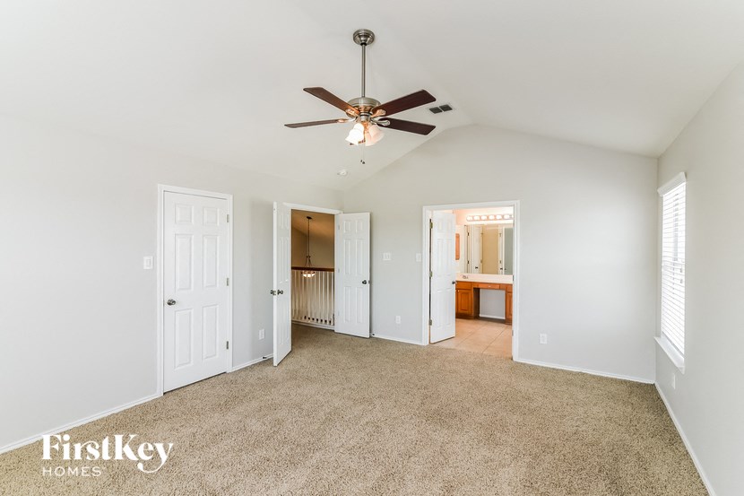 a living room with carpet and a ceiling fan