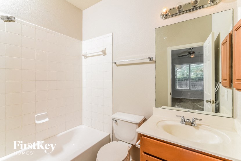 a bathroom with a toilet sink and tub and a mirror