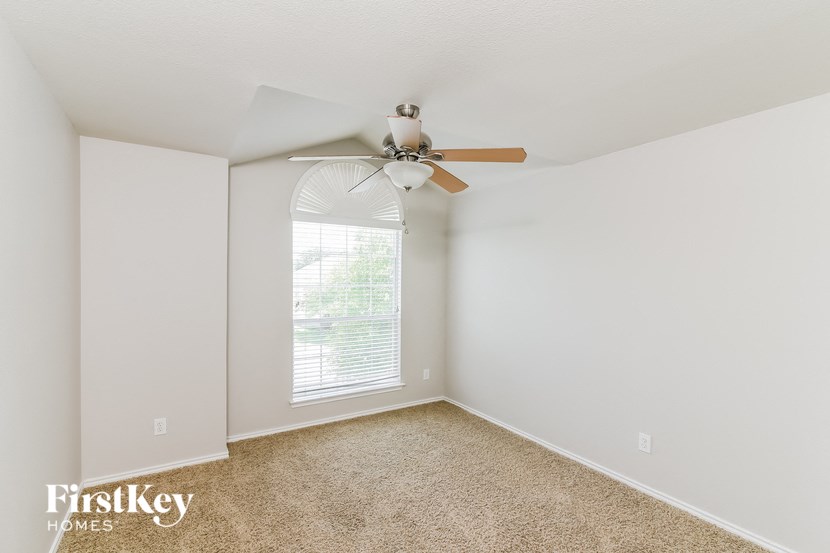 a bedroom with a ceiling fan and a window