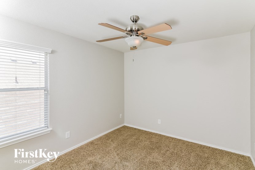 a bedroom with a ceiling fan and a window