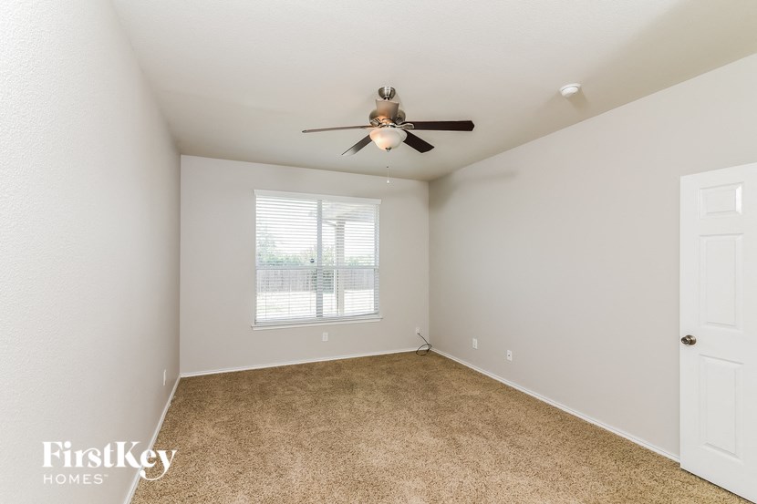 a bedroom with a ceiling fan and a window