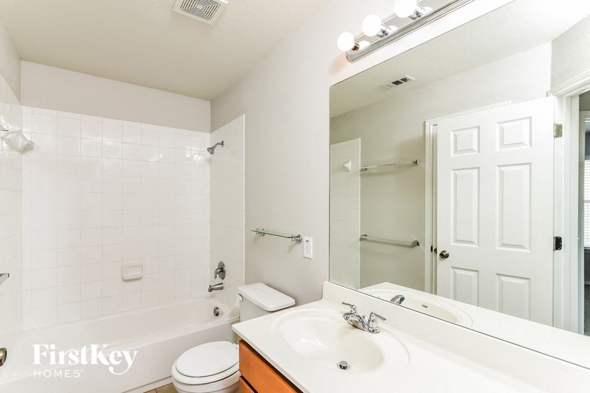 a bathroom with a sink and a mirror and a bath tub