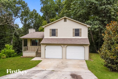 a white house with a white garage with a driveway
