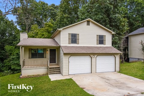 a white house with a garage and a driveway