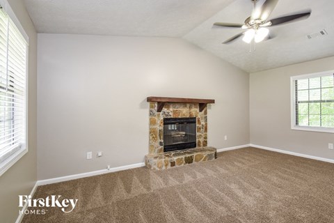 a living room with a fireplace and a ceiling fan