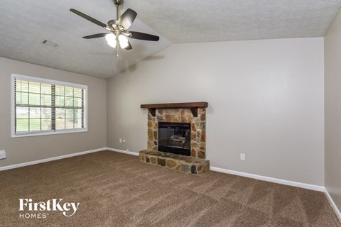 a living room with a fireplace and a ceiling fan