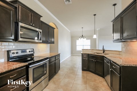 a kitchen with black cabinets and stainless steel appliances and marble counter tops