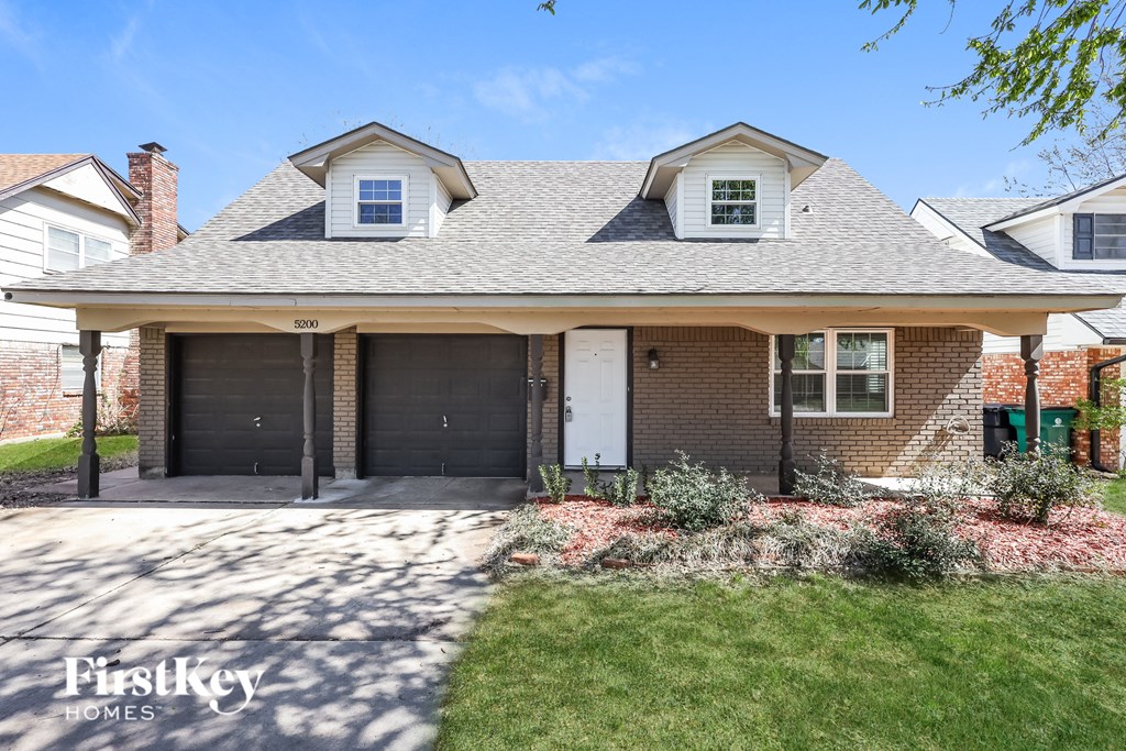front view of a brick house with two garage doors