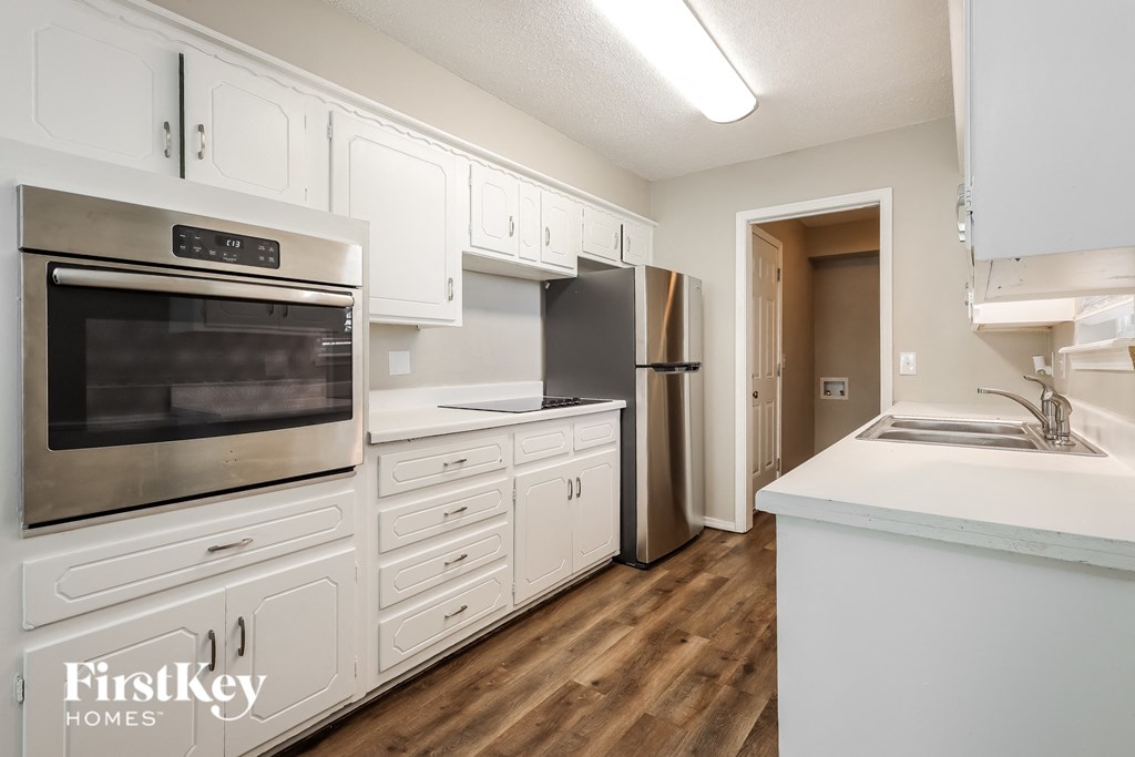 a kitchen with white cabinets and stainless steel appliances