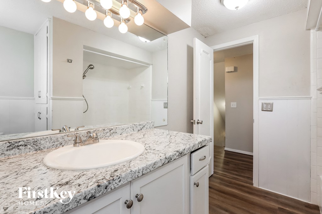 a bathroom with a sink and a mirror and a shower