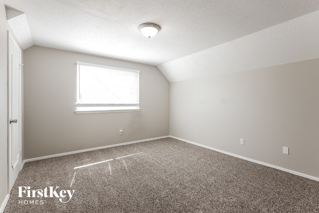 a bedroom with carpet and a window