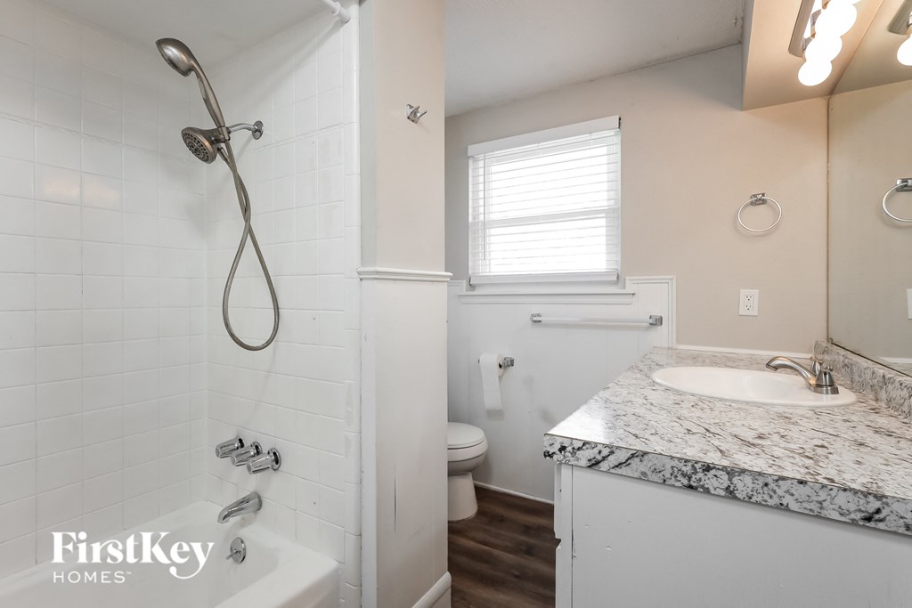 a bathroom with a tub sink and shower and a toilet