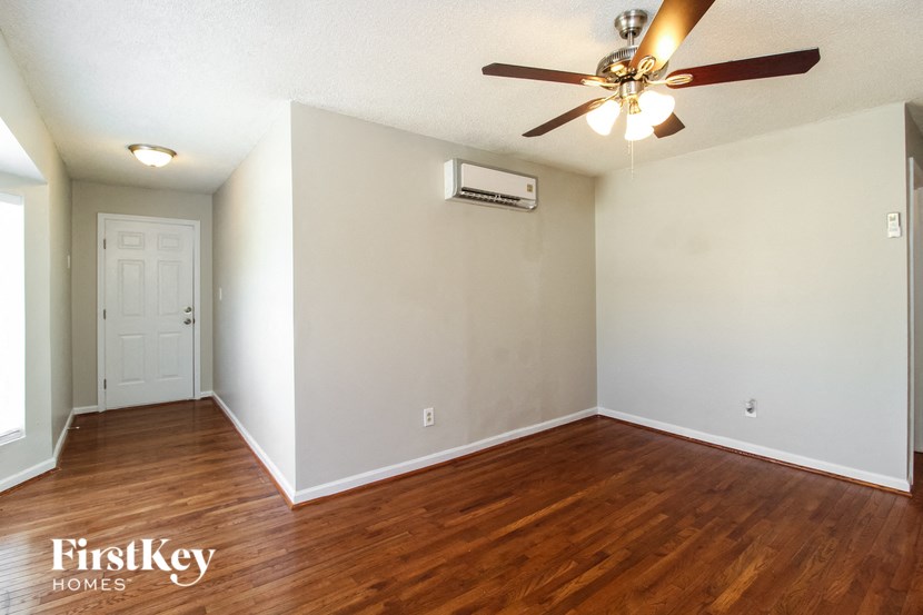 the living room of an empty house with a ceiling fan