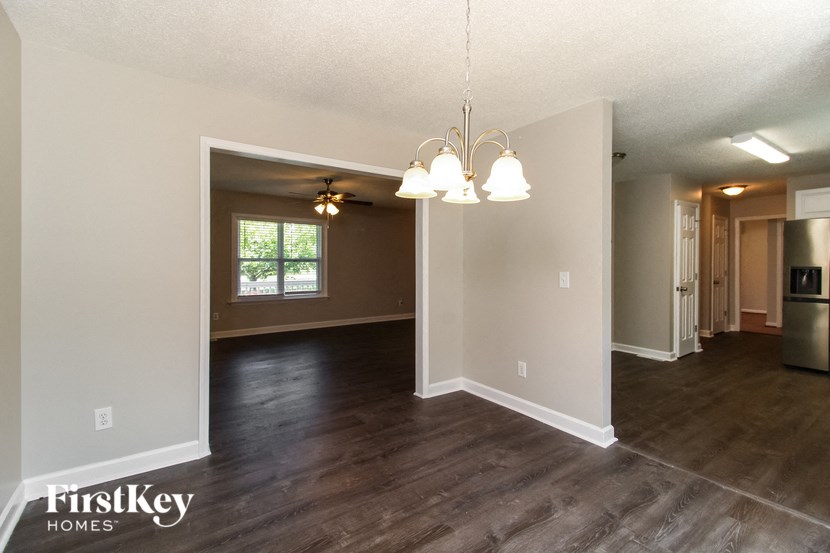 the living room and dining room of an empty house
