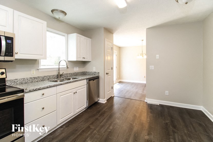 a kitchen with white cabinets and a sink and a microwave