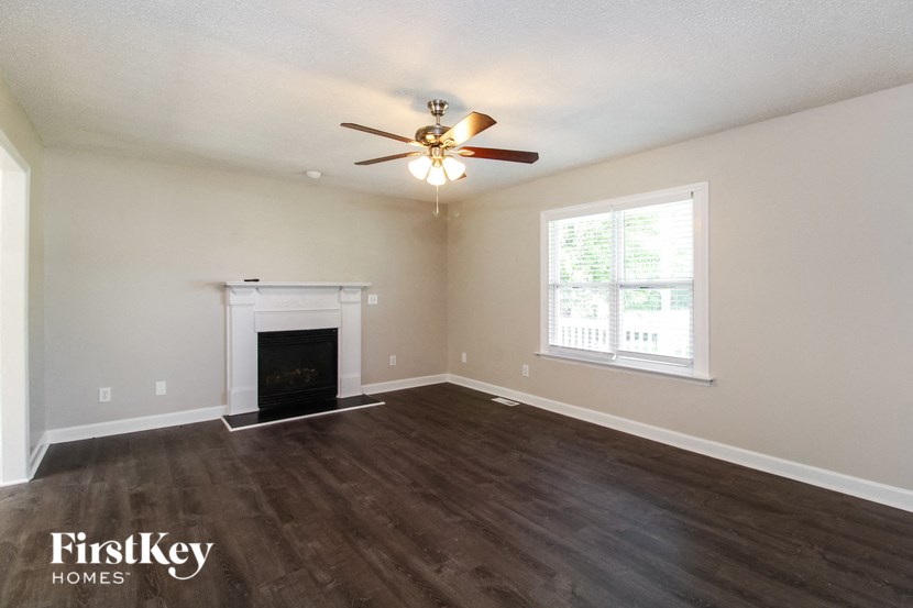 a living room with a fireplace and a ceiling fan