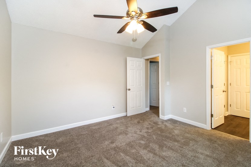 a living room with carpet and a ceiling fan