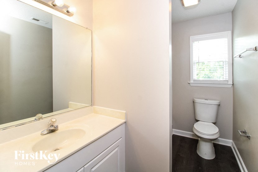 a bathroom with a toilet and a sink and a mirror