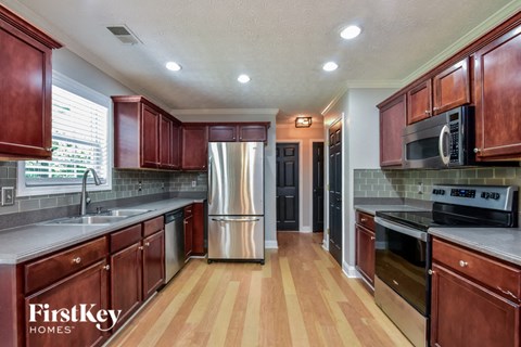 A kitchen with wooden cabinets and a stainless steel refrigerator.