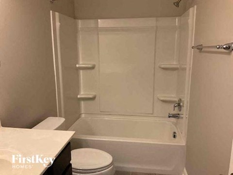 a white bathroom with a toilet and a bath tub