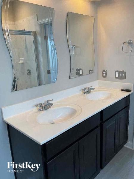 a bathroom with two sinks and two mirrors