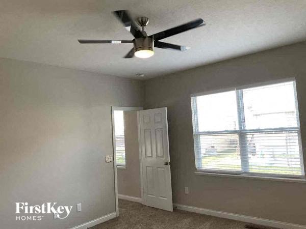 a bedroom with a ceiling fan and a window