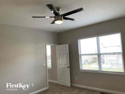 a bedroom with a ceiling fan and a window
