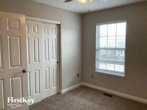 an empty room with a white door and a window