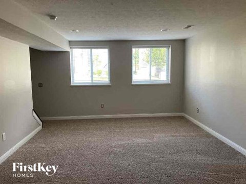 an empty empty room with two windows in it