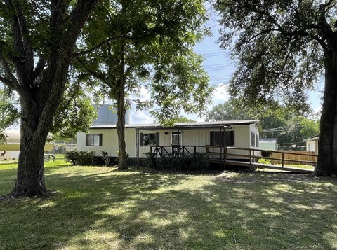 A house with a porch surrounded by trees.