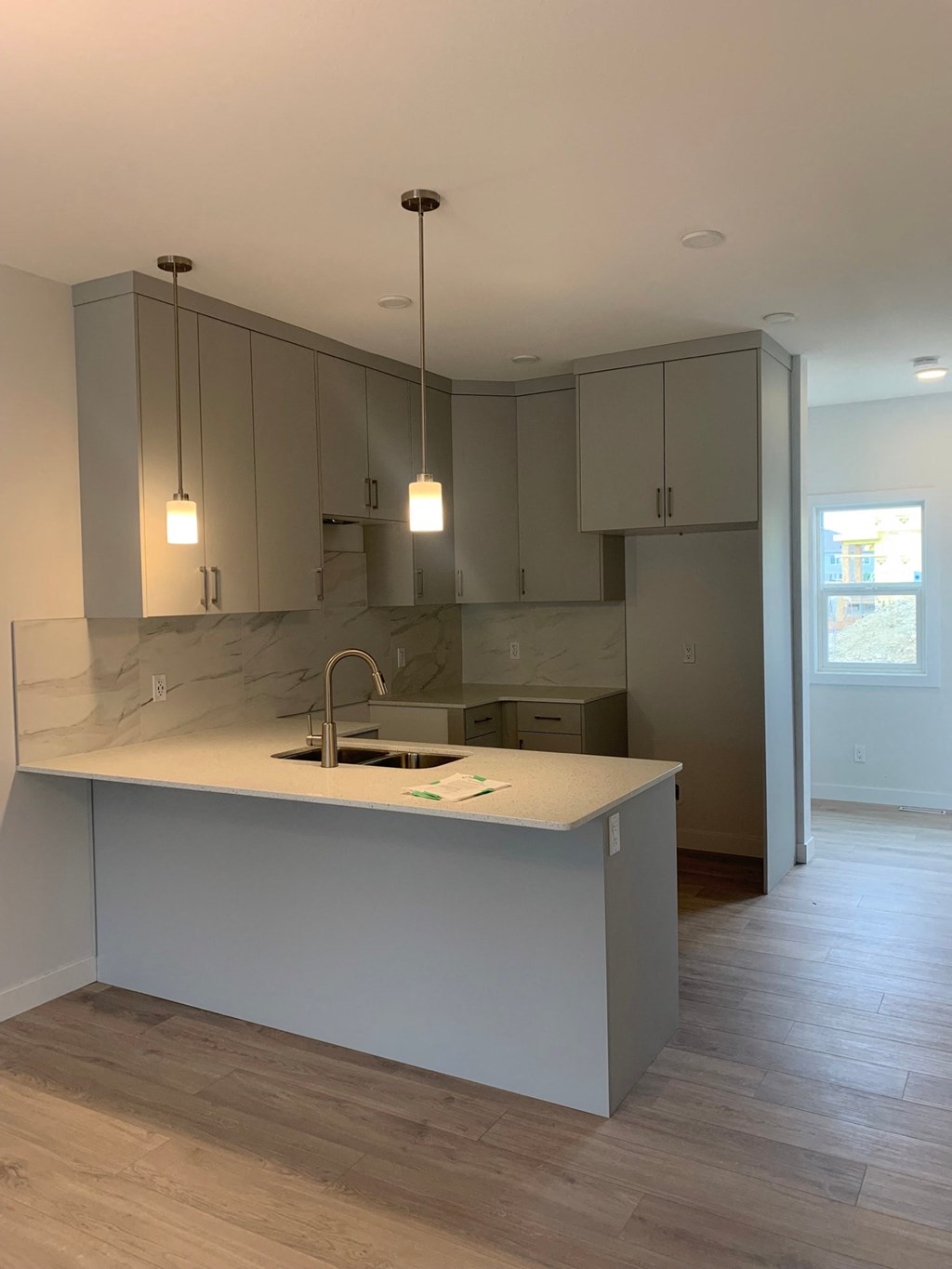 an empty kitchen with white cabinets and a sink