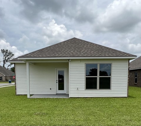 a small white house in a grassy yard