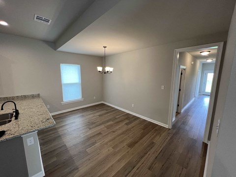 a dining room and living room with hard wood floors and a window