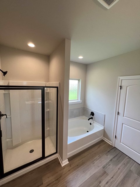a large white bathroom with a tub and a shower