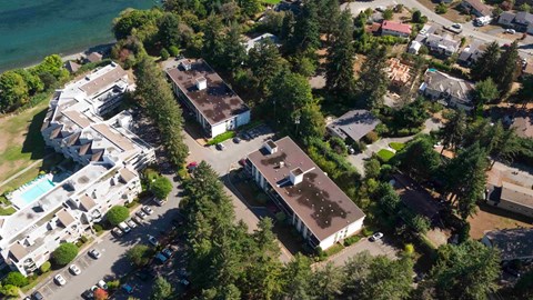 An aerial view of a resort with a swimming pool and a parking lot.